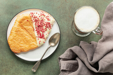 Flat Croissants, Trendy Pastry, Croissant with chocolate icing and pastry sprinkles. Top view