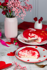 heart-shaped mousse cake in red glaze with gold decor on a white plate, red and pink carnations, roses, gypsophila in a vase, Valentine's Day cake, birthday, light background, food photo