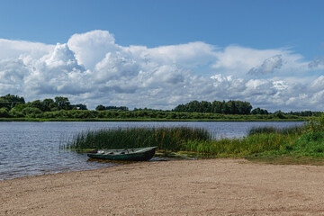 boat in the water by the river in summer with clouds in the sky