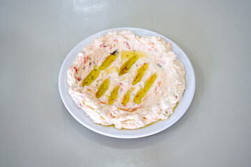 Close up turkish traditional hot spicy appetizer Atom ingredients with aubergine, yogurt and cooked oily hot pepper sauce.