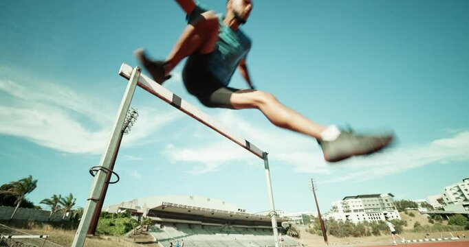 Below, man and running for hurdle outdoor of fitness competition, exercise event and sports performance. Male runner, jump and obstacle race for cardio training, workout challenge and endurance goals