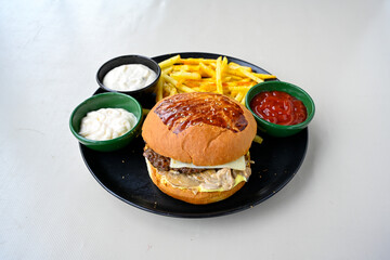 Big tasty burger with beef cutlet on a plate. Hamburger, cheeseburger with mushroom. Hamburger, Mexica, mushroom double burger.  Crispy chicken burger. With french fries, patates kizartmasi.