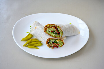 Cig kofte (raw meatball) with lettuce, tomato, pickle and lemon, hot Chee kofta. Turkish local raw food concept.Table scene of assorted take out or delivery foods. Doritoslu duble cig kofte durum.