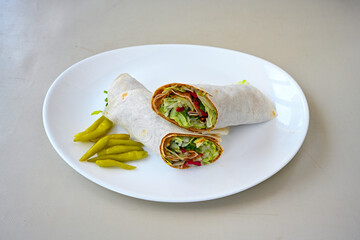 Cig kofte (raw meatball) with lettuce, tomato, pickle and lemon, hot Chee kofta. Turkish local raw food concept.Table scene of assorted take out or delivery foods. Doritoslu duble cig kofte durum.