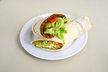 Cig kofte (raw meatball) with lettuce, tomato, pickle and lemon, hot Chee kofta. Turkish local raw food concept.Table scene of assorted take out or delivery foods. Doritoslu duble cig kofte durum.