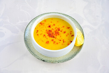 Lentil ( mercimek corbasi ) soup with melted butter and red pepper sauce. Limon ve soslu mercimek corba.
