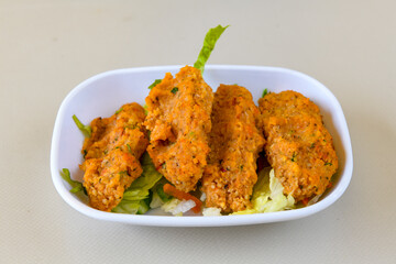 Cig kofte (raw meatball) with lettuce, tomato, pickle and lemon, hot Chee kofta. Turkish local raw food concept.Table scene of assorted take out or delivery foods. Doritoslu duble cig kofte durum.