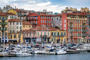 Red and orange buildings in Nice, France, boats and yachts at the Lympia port