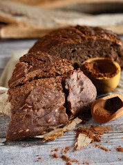 Sliced cocoa bread with cocoa powder on rustic wooden table