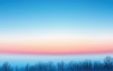 Obraz premium A serene blue sky with a gentle gradient and silhouettes of trees at the horizon.