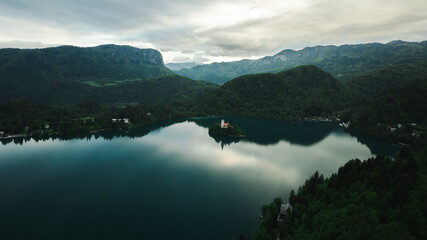 Aerial view of Church of the Assumption of Mary in the center of the lake Bled. Flying around small...