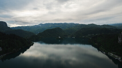 Obraz premium Aerial view of Church of the Assumption of Mary in the center of the lake Bled. Flying around small island on Bled Lake in Slovenia