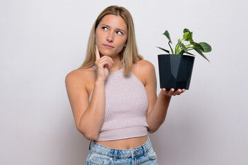 Thoughtful blonde girl with plant