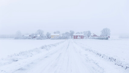Fototapeta premium Farm barn and house in a cold wintry landscape with snow anf frost