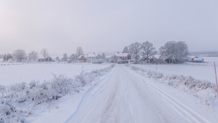 Farm barn and house in a cold wintry landscape with snow anf frost