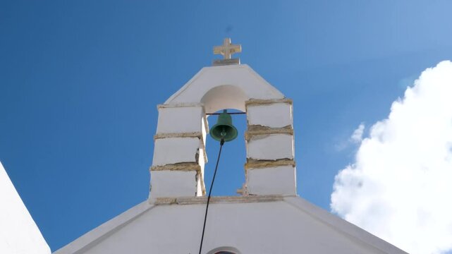 Church bell ringing belfry bright white stone with cross on top, has electrical mechanism instead of a rope. High quality 4k footage