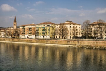 Obraz premium verona, italien - uferpromenade mit kirchturm an der etsch