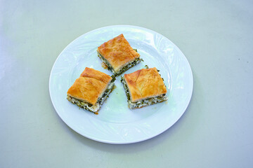 Turkish style meat stuffed filo dough borek served kol boregi. Cheese and minced pie are sliced on a marble background.  Avci boregi.Turkish name: Kol Boregi. Kiymali, peynirli su boregi.