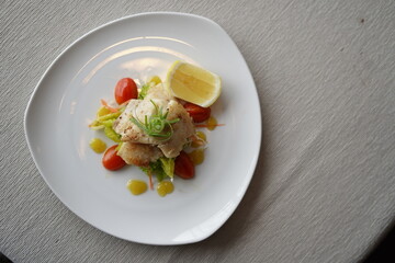 Elegant Plated Fish Dish with Lemon and Tomatoes