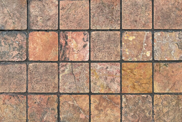 Obraz premium Unique natural stone marble tiles wall texture in mix of brown, orange, and red color with random abstract veins. Honed and rough outdoor marble tiles wall seamless background.