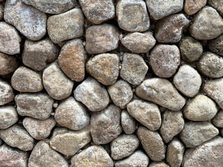 Close up of pebble stone wall as decorative material on landscape garden wall finishes. Cemented pebbles are good choice for quartz decoration in gardening.