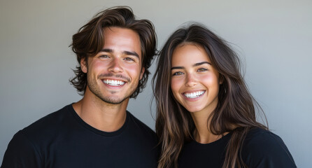 An attractive young couple stands close, smiling brightly and radiating joy in a casual environment. Their chemistry is evident