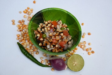 Grilled corn Chaat. Indian style corn salad that's sweet, spicy and tangy. It is mixed with chaat masala, roasted cumin powder, red chili powder, coriander leaves, onion and tomatoes. Indian snacks.