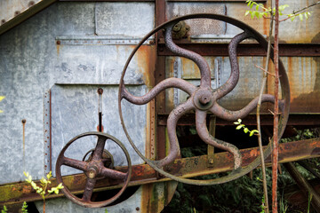 Rusting Iron, Gears and Flywheels of Abandoned Threshing Machine on Old Farm 