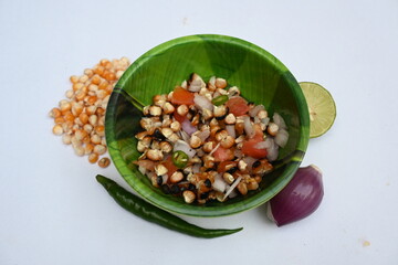 Grilled corn Chaat. Indian style corn salad that's sweet, spicy and tangy. It is mixed with chaat masala, roasted cumin powder, red chili powder, coriander leaves, onion and tomatoes. Indian snacks.