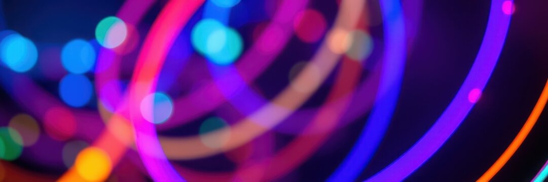 Colorful light trails swirl and dance in a vibrant abstract display during a lively night event