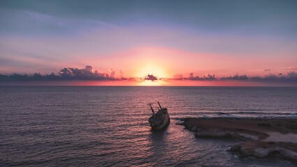Sunset over ocean with shipwreck  in Paphos, Cyprus