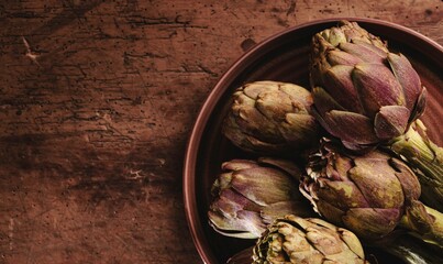 Freshly harvested artichokes rest on an earthy wooden table, symbolizing the beauty of local ingredients and the art of slow cooking, connecting nature and nourishment in a mindful way