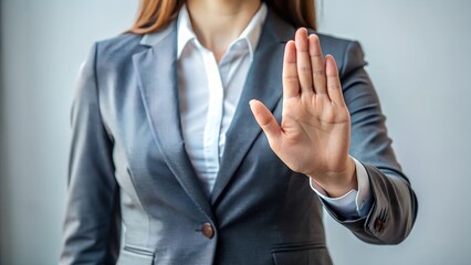Stop hand sign and woman in a business suit, representing caution, warning, and professional decision-making.