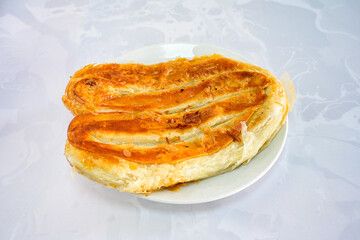 Turkish style meat stuffed filo dough borek served kol boregi. Cheese and minced pie are sliced on a marble background.  Avci boregi.Turkish name: Kol Boregi. Kiymali, peynirli su boregi.