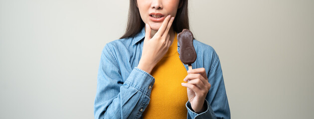 Face expression suffering from sensitive teeth, Asian young woman touching cheek