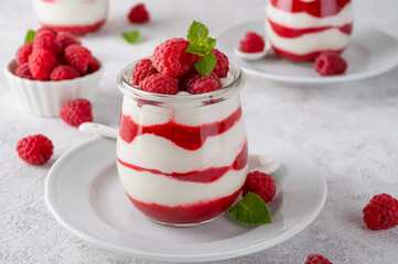 Vanilla white chocolate mousse, trifle, panna cotta or parfait with raspberry sauce in a glass jar....