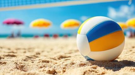 Obraz premium vibrant volleyball resting on sandy beach with colorful umbrellas in background