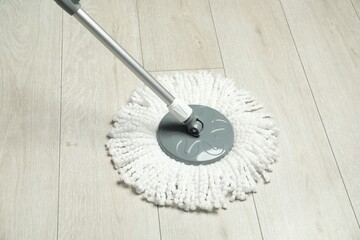 String mop on wooden floor. Cleaning equipment