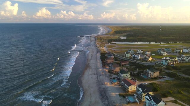 Cape Hatteras at Sunset. The Atlantic Ocean shore, hotels, villas and the Cape Hatteras Lighthouse.
