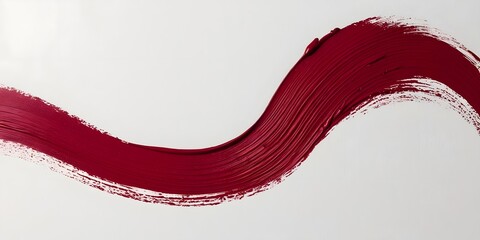 A textured brushstroke in deep red ink, streaking across a blank white page, forming a fluid, artistic expression