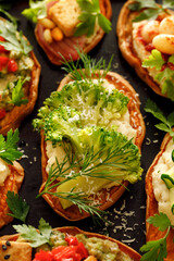 Sweet potato toasts with various vegetarian toppings, focus on the middle toast with broccoli and bean paste, close-up view., top view
