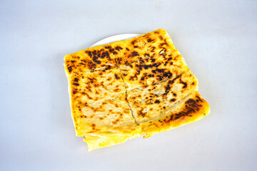 Freshly baked appetizing Turkish tortillas - Gozleme with spinach, cheese  on a white board. Space for text. Handmade Turkish traditional pastries. Ispanakli, otlu peynirli gozleme. Tahinli Katmer