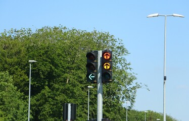close-up of a traffic light, left turners have a green arrow and straight ahead is just turning green