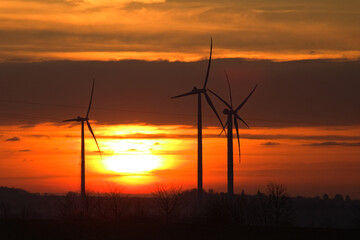 Wind power plant landscape at sunset time with dramatic sky.Wind farm at sunset. Pure energy, wind turbine. Wind turbines farm. Sunset Landscape.