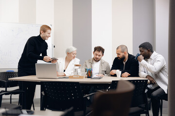 Diverse group of professionals engaged in interactive business strategy meeting. participants include african american, asian, and caucasian individuals discussing ideas around conference table.