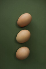 chicken eggs lie on a green background, top view
