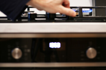 A cook lights a gas stove to cook food.