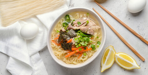 Composition with tasty Chinese soup on light background