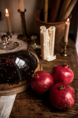 Three red pomegranates on a wooden table.