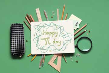 Blank notebook with pencil case and different stationery supplies on green background